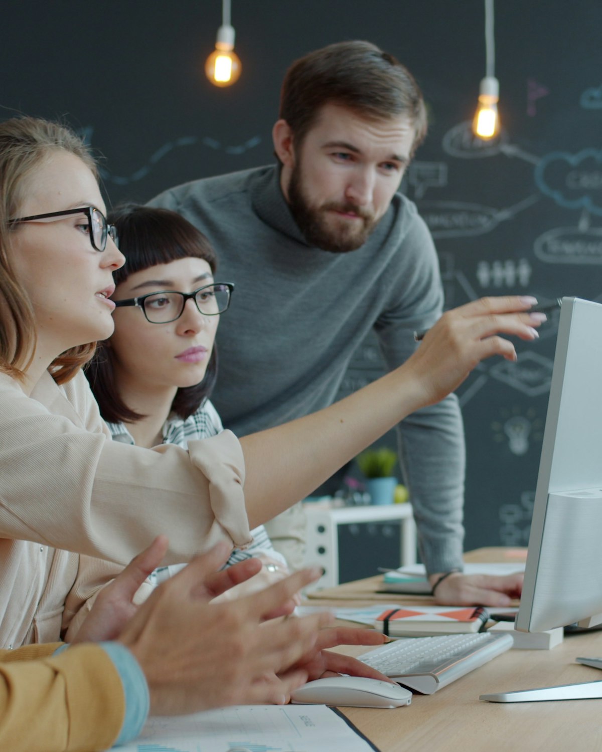 Colleagues discussing a project around a laptop